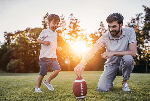 father and son playing football